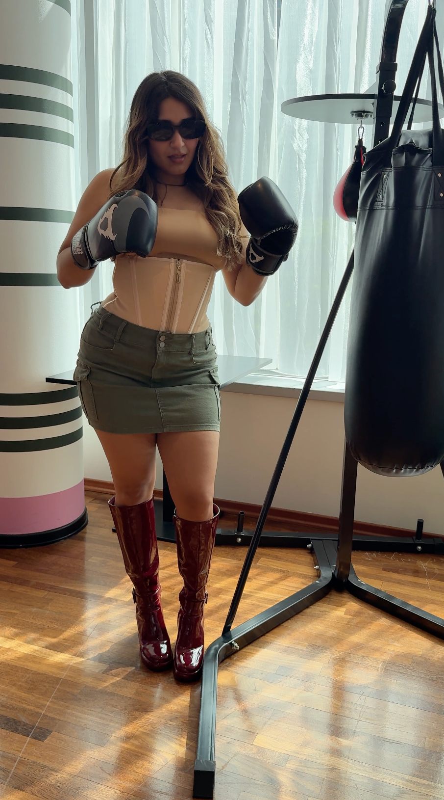 Beigefarbene Shapewear zu olivgrünem Rock und burgunderfarbenen Stiefeln